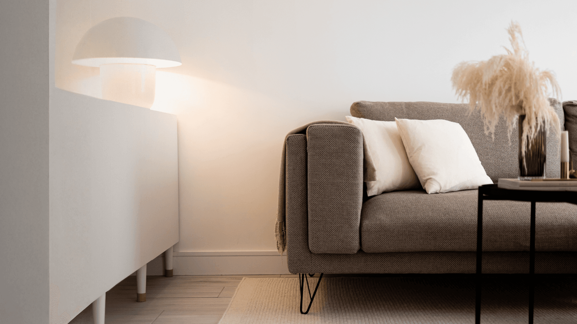 Modern living room with brown fabric sofa, minimalist lighting, and neutral home decor