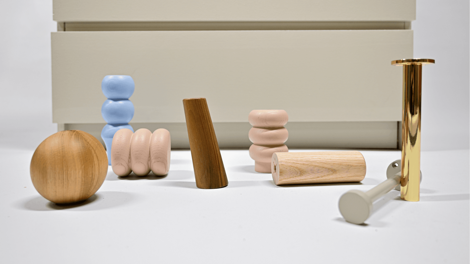 Furniture legs in wood, metal and color finishes displayed in front of an IKEA MALM dresser