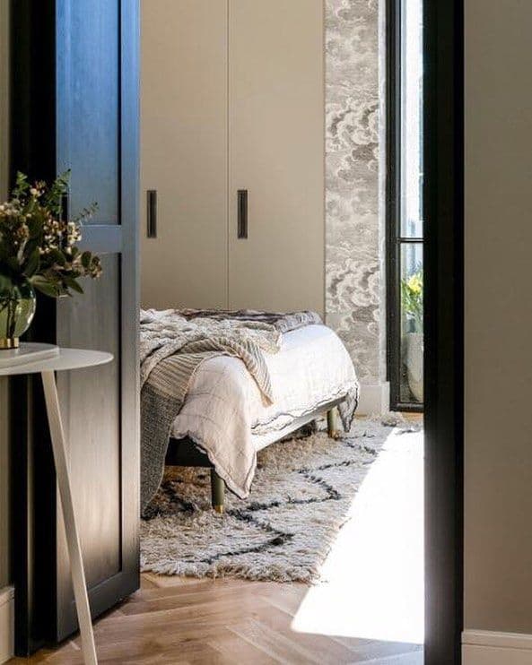 IKEA bed with metal legs in a stylish bedroom with layered textures and rug